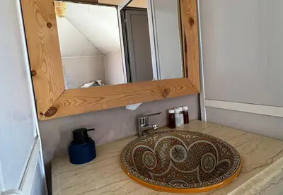 a bathroom with a sink and a mirror at Celestial Dunes Camp in Merzouga