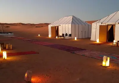 a group of tents in the desert at night at Merzouga Atlantis in Merzouga