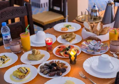 a wooden table with plates of food on it at Merzouga Atlantis in Merzouga