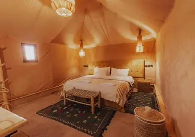 a bedroom in a tent with a bed in it at Merzouga Atlantis in Merzouga