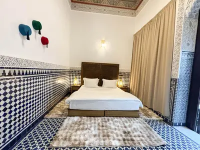 a bedroom with a bed with blue and white tiles at Riad Azul Fes & SPA in Fès