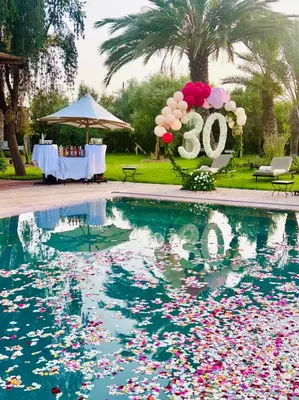 a swimming pool with a sign that says with flowers at Villa Ishtar in Marrakech
