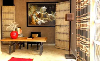 a room with a table and a painting on the wall at Villa Ishtar in Marrakech