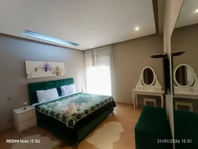 a bedroom with a bed and two mirrors on the wall at Résidence chic et sécurisé - 2 chambres à Prestigia in Fès