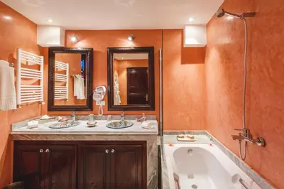 a bathroom with two sinks and a bath tub at Riad Fes Maya suite & spa in Fès