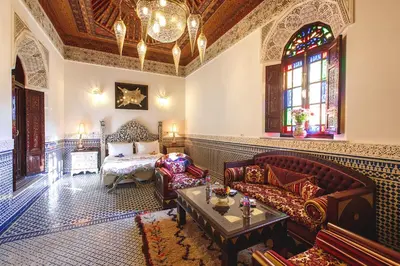 a living room with furniture and a stained glass window at Riad Fes Maya suite & spa in Fès