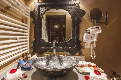 a bathroom with a sink and a mirror at Riad Fes Maya suite & spa in Fès
