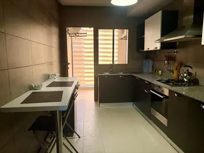 a kitchen with black cabinets and a white counter top at Résidence Prestigia Fès centre - 3 chambres in Fès