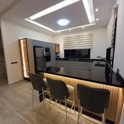 a kitchen with three chairs and a counter with a stove at Villa Imane in Marrakech private pool in El Aouina
