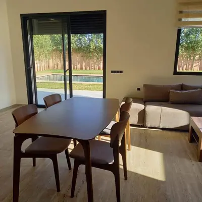 a living room with a table and chairs and a couch at Villa Imane in Marrakech private pool in El Aouina