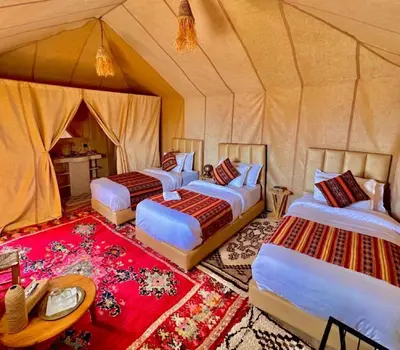 a group of four beds in a tent at Camping Activities Merzouga in Merzouga