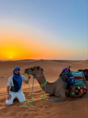 a man sitting on a camel in the desert at Camping Activities Merzouga in Merzouga