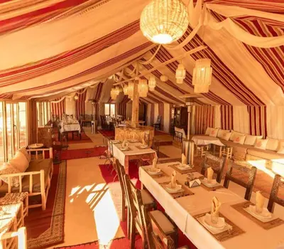 a large tent with tables and chairs in a room at Camping Activities Merzouga in Merzouga