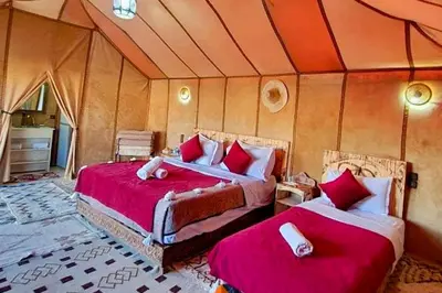 a bedroom with two beds in a tent at Camping Activities Merzouga in Merzouga