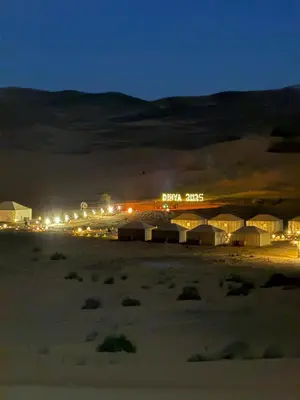 a view of a desert at night with buildings at Morocco Desert Camp in Merzouga