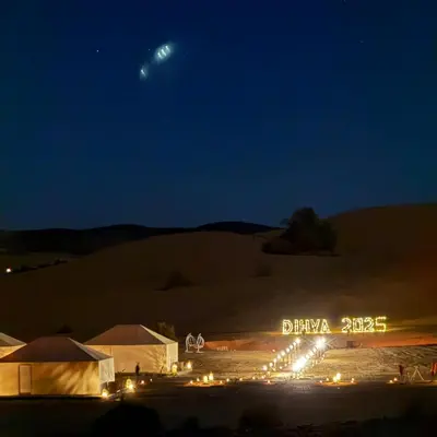a group of tents in a desert at night at Morocco Desert Camp in Merzouga