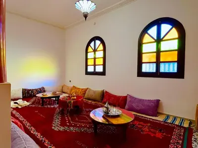 a living room with a couch and two windows at Palais Aya in Oulad Akkou