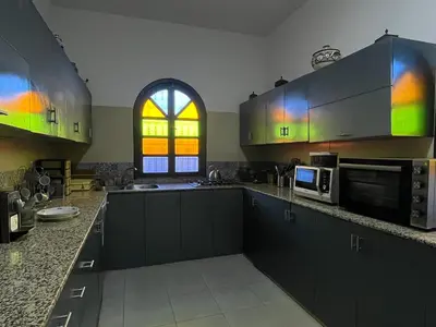 a kitchen with green cabinets and a window at Palais Aya in Oulad Akkou
