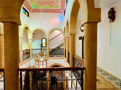 a hallway of a building with arches and a chandelier at Palais Aya in Oulad Akkou