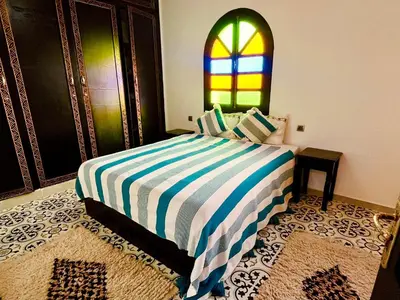 a bedroom with a bed with a stained glass window at Palais Aya in Oulad Akkou
