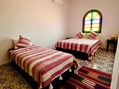 a bedroom with two beds and a window at Palais Aya in Oulad Akkou
