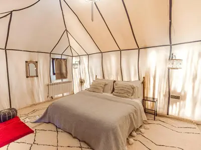 a bedroom with a bed in a tent at Arsura Luxury Camp in Merzouga
