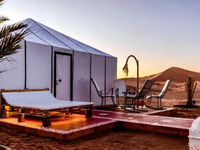 a blue building in the middle of the desert at Arsura Luxury Camp in Merzouga