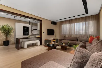 a living room with a couch and a large window at Modern Loft in City Center in Oulad Akkou