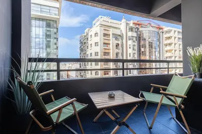 a pair of chairs and a table on a balcony at Modern Loft in City Center in Oulad Akkou