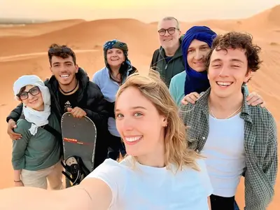 a group of people posing for a picture in the desert at Merzouga Standard Camp in Merzouga