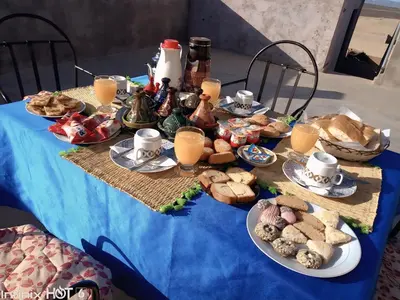 a table with a blue table cloth with food on it at Merzouga Standard Camp in Merzouga
