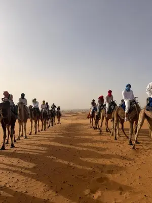 a group of people riding horses on the desert at Royal Erg Chebbi Luxury Camp in Hassilabied