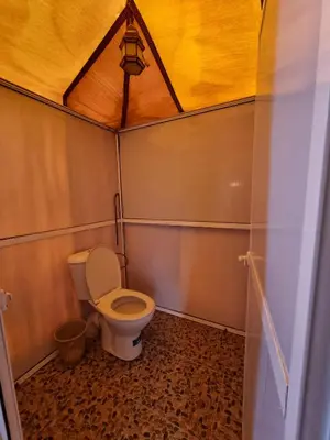a small bathroom with a toilet in a tent at Aziz luxury camp in Merzouga