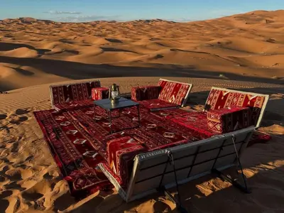 a table in the middle of the desert at Global Desert Luxury Camp in Merzouga