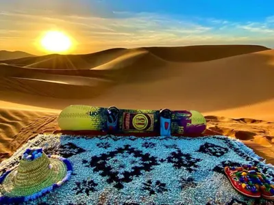 a table in the middle of a desert with a hat at Global Desert Luxury Camp in Merzouga