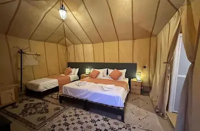 a bedroom with two beds in a tent at Merzouga palace camp in Merzouga