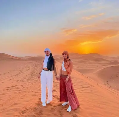 a man and a woman standing in the desert at Merzouga palace camp in Merzouga