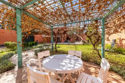 a table and chairs sitting under a pergola at Private Villa with Pool and Hammam Marrakech in Oulad Akkou