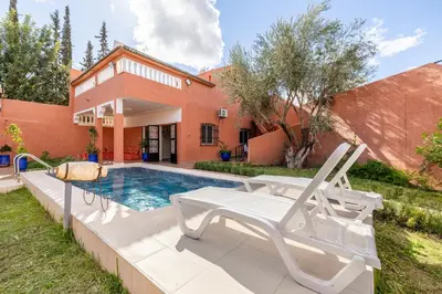 a swimming pool with a white chair next to a house at Private Villa with Pool and Hammam Marrakech in Oulad Akkou