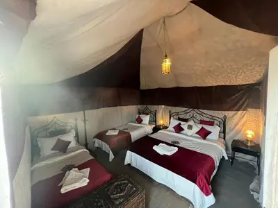 a bedroom with two beds in a tent at Luxury camp desert in Merzouga
