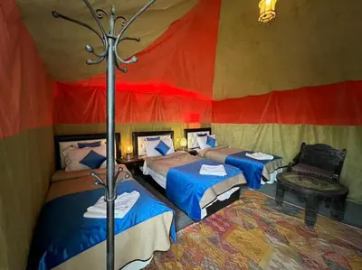 a room with three beds in a tent at Luxury camp desert in Merzouga