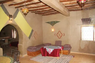 a room with a table and chairs and a window at dorada apartamento in Merzouga