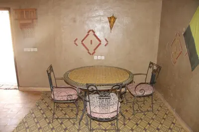 a table and four chairs in a room at dorada apartamento in Merzouga