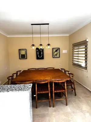 a dining room with a wooden table and chairs at Dar Laydam in Aït Zat
