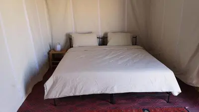 a bed with two pillows on it in a room at Colorado Desert Camp in El Gouera