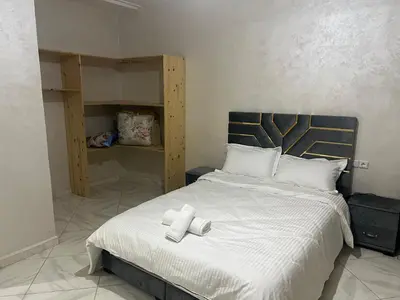 a bedroom with a large bed with white sheets at Université luxe appart2 in Fès