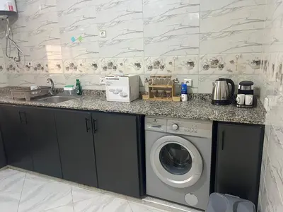 a kitchen with a washing machine and a sink at Université luxe appart2 in Fès