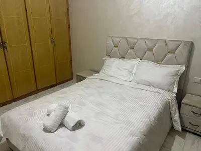 a bedroom with a white bed with two towels on it at Université luxe appart2 in Fès