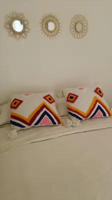 a bed with two pillows and two mirrors on the wall at chez dar Ayoub in Fès