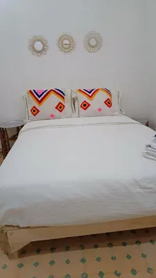a bed with white sheets and pillows on it at chez dar Ayoub in Fès